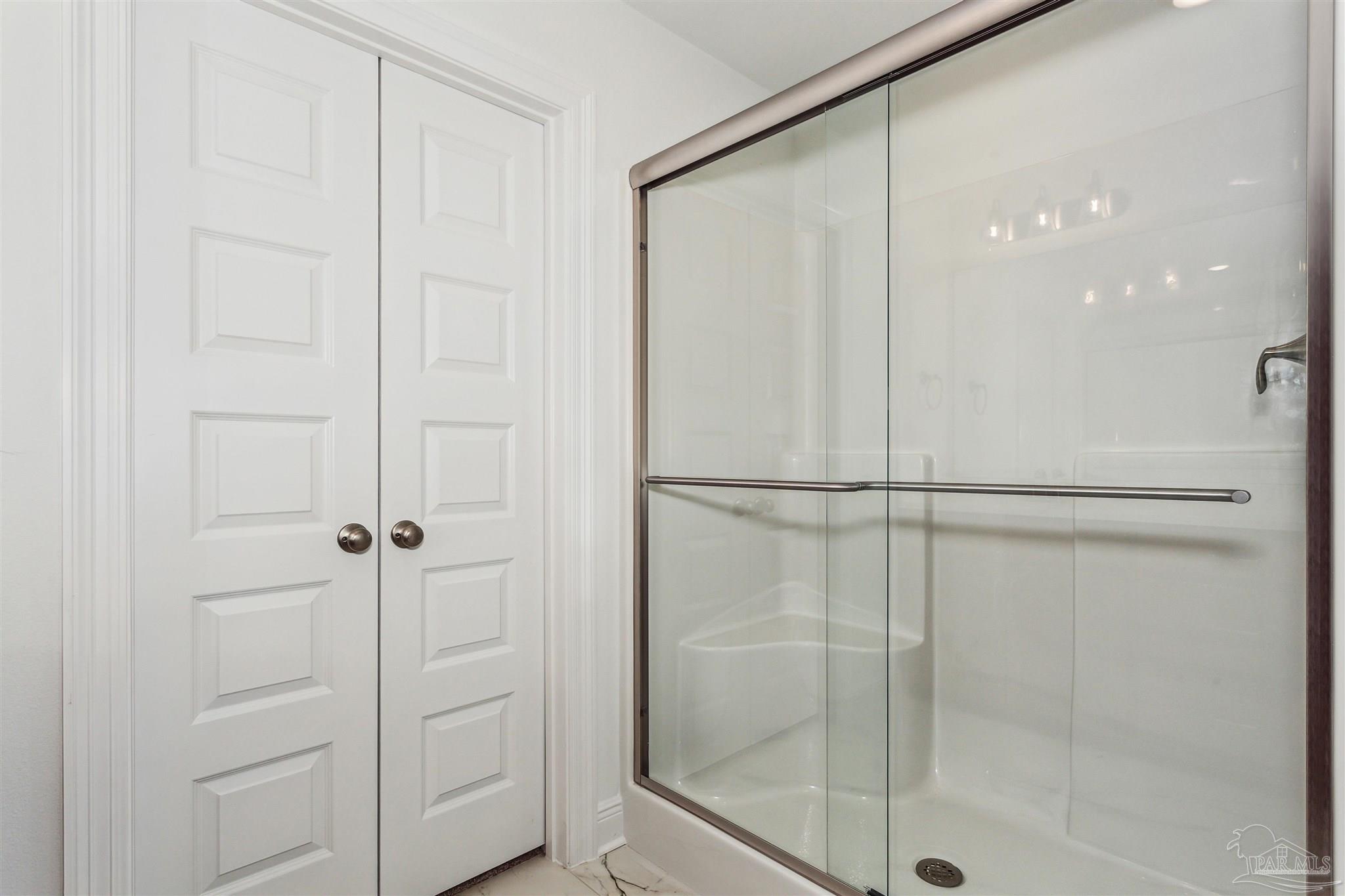 9319 Salter Road Pace, FL 32571 - Photo 26 of 32 a bathroom with a glass shower door
