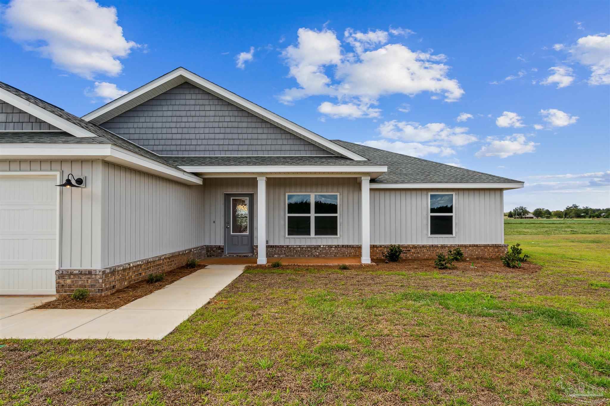 9319 Salter Road Pace, FL 32571 - Photo 3 of 32 a front view of house with yard and trees in the background
