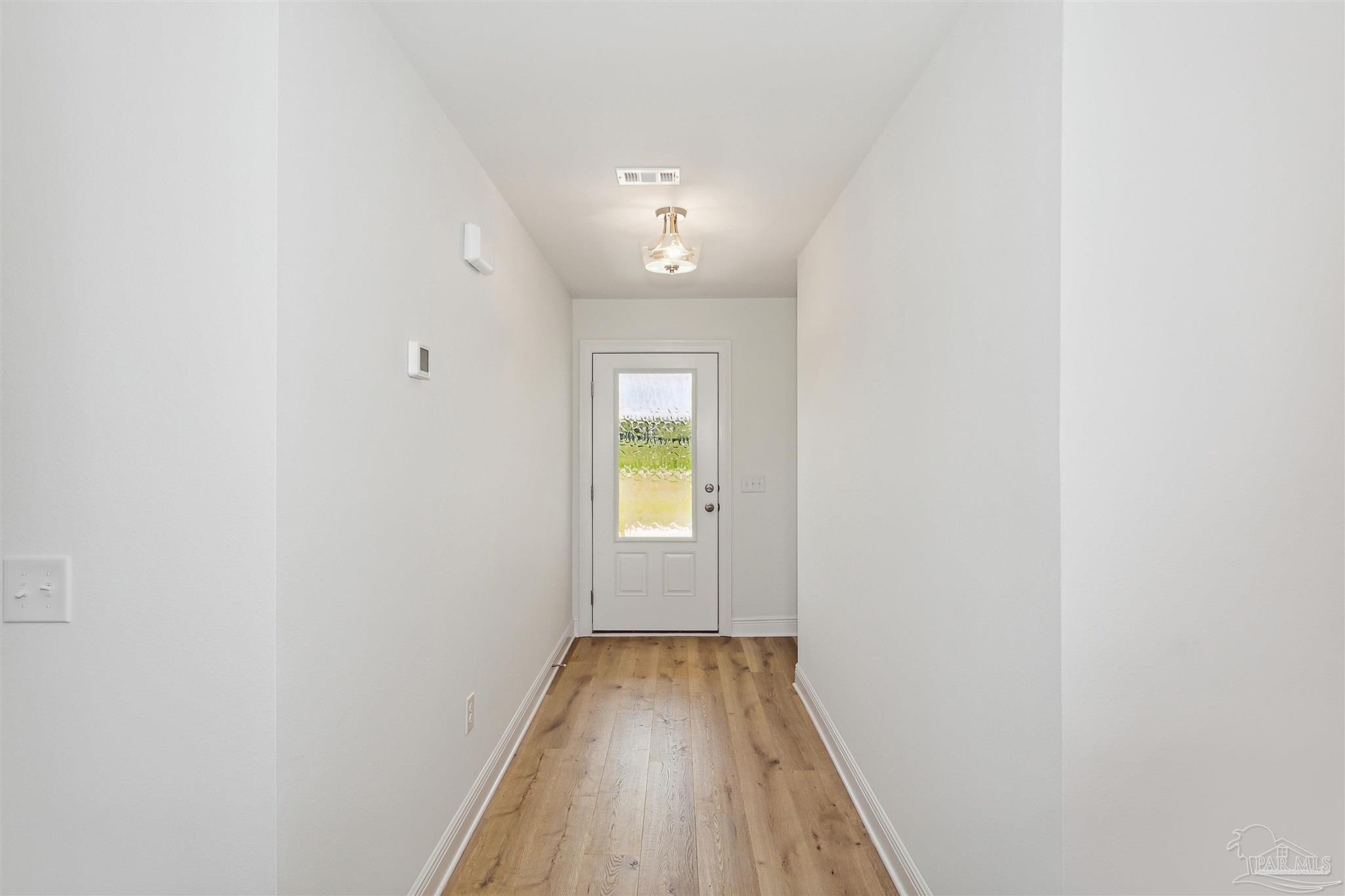 9319 Salter Road Pace, FL 32571 - Photo 4 of 32 a view of a hallway with wooden floor