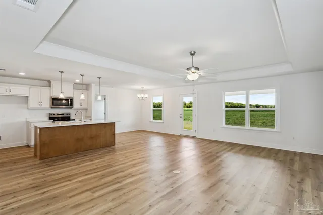 a view of kitchen with sink a refrigerator and a large window