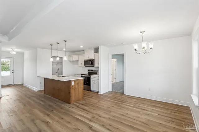 a large kitchen with kitchen island a sink stainless steel appliances and cabinets
