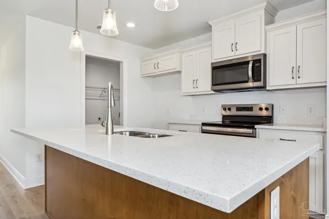 a kitchen with stainless steel appliances a stove a microwave a sink and cabinets