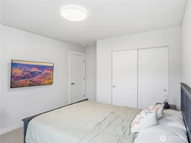 a bedroom with a bed and a painting on the wall