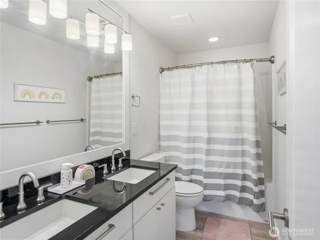 a bathroom with a sink a toilet and shower curtain