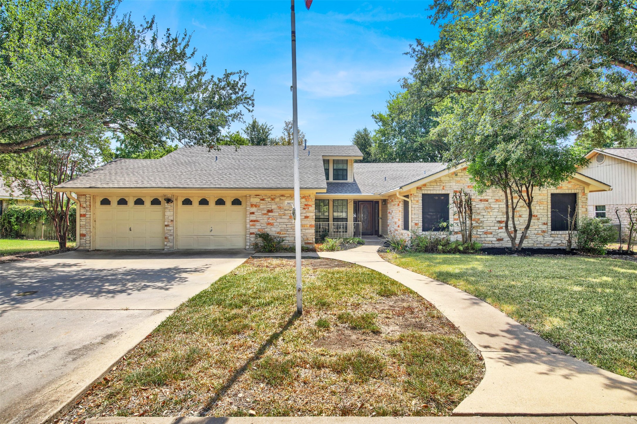 1403 Stone Ridge Drive Taylor, TX 76574 - Photo 1 of 1 View of front of house featuring a shingled roof, a front lawn, driveway, an attached garage, and stone siding