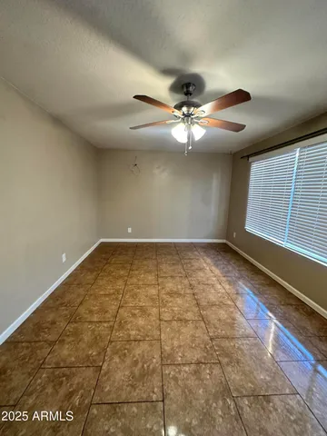 en empty room with windows and ceiling fan