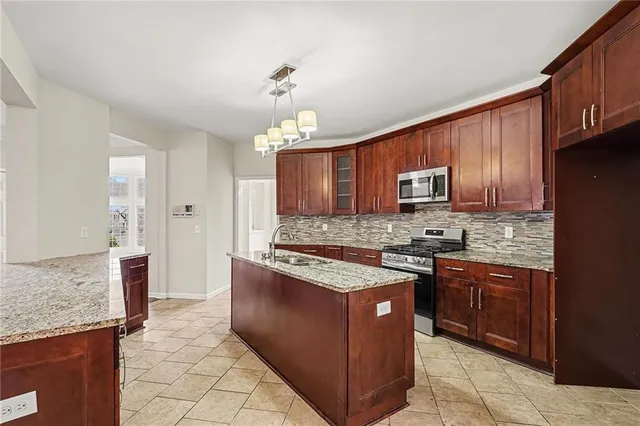 a kitchen with stainless steel appliances granite countertop wooden cabinets a stove top oven a sink and dishwasher