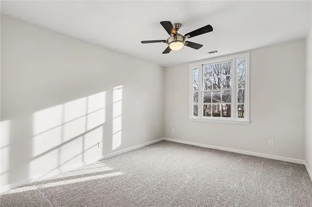 a view of a livingroom with a ceiling fan and window