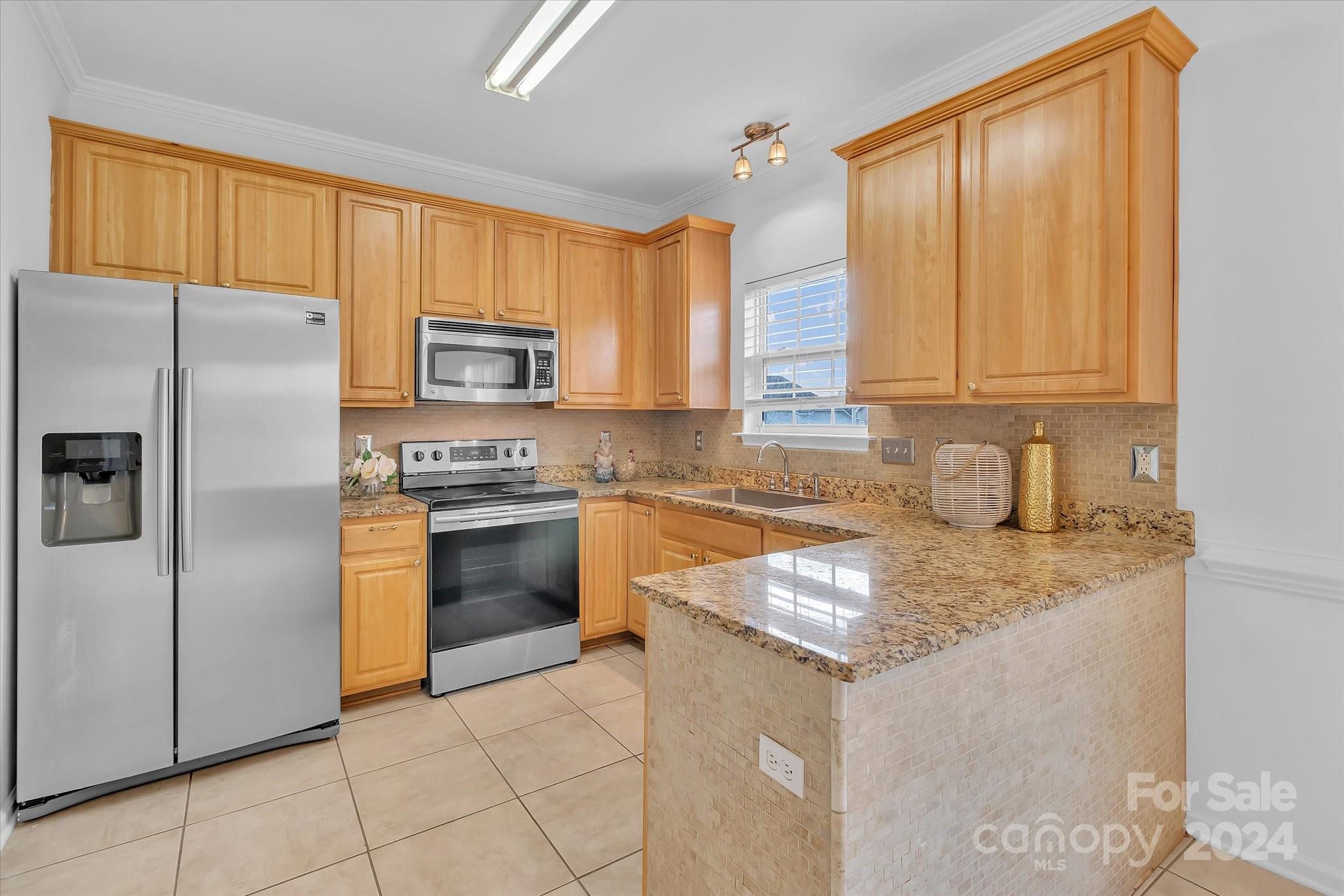 1004 Kipling Court Indian Trail, NC 28079 - Photo 13 of 42 a kitchen with granite countertop a refrigerator stove top oven and sink