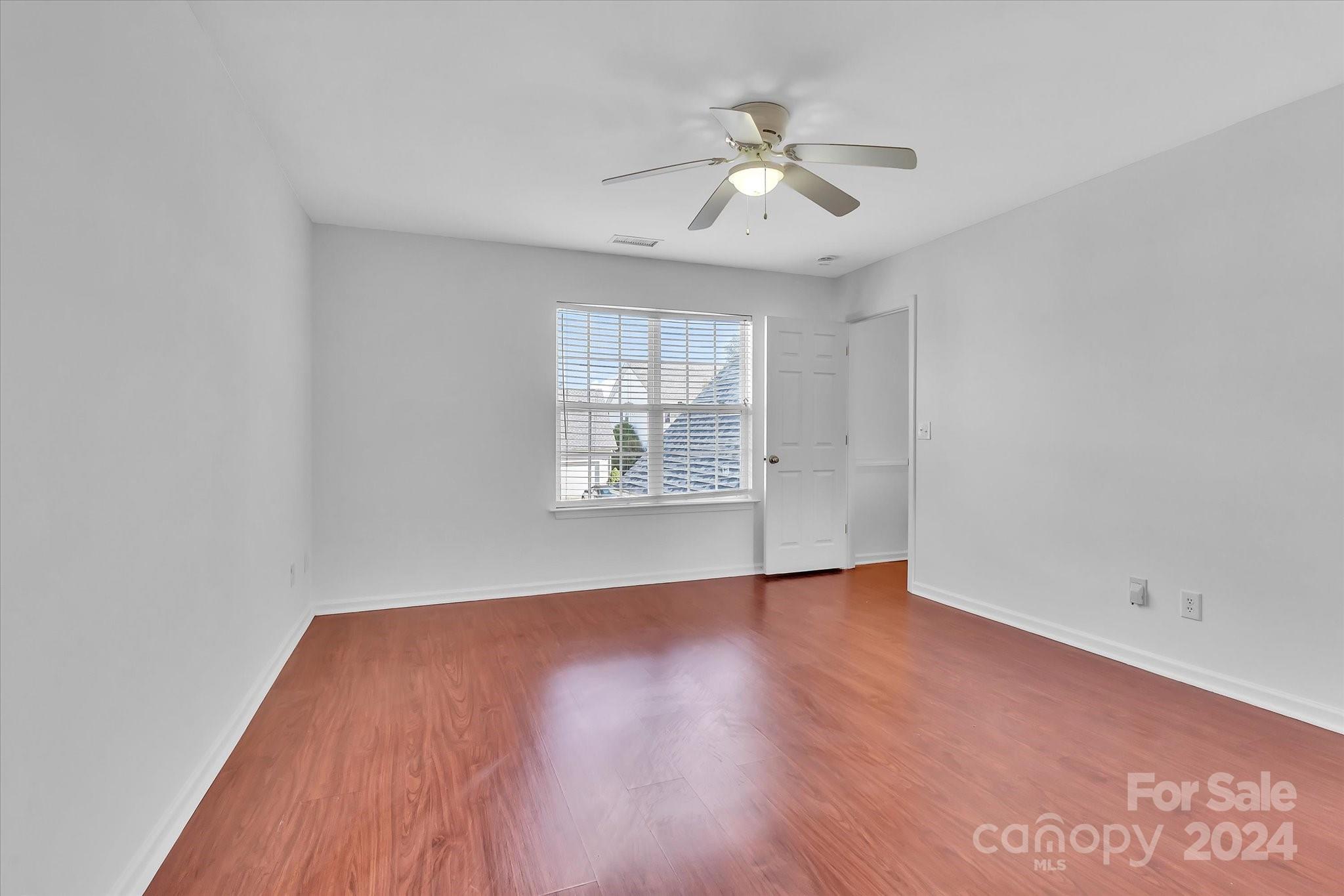 1004 Kipling Court Indian Trail, NC 28079 - Photo 26 of 42 an empty room with wooden floor chandelier fan and windows