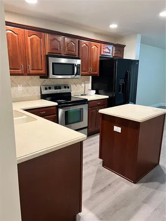 a kitchen with stainless steel appliances a refrigerator stove microwave and sink