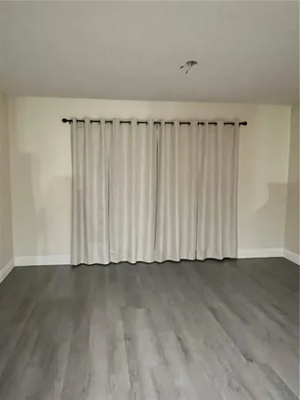a view of a room with wooden floor and a window