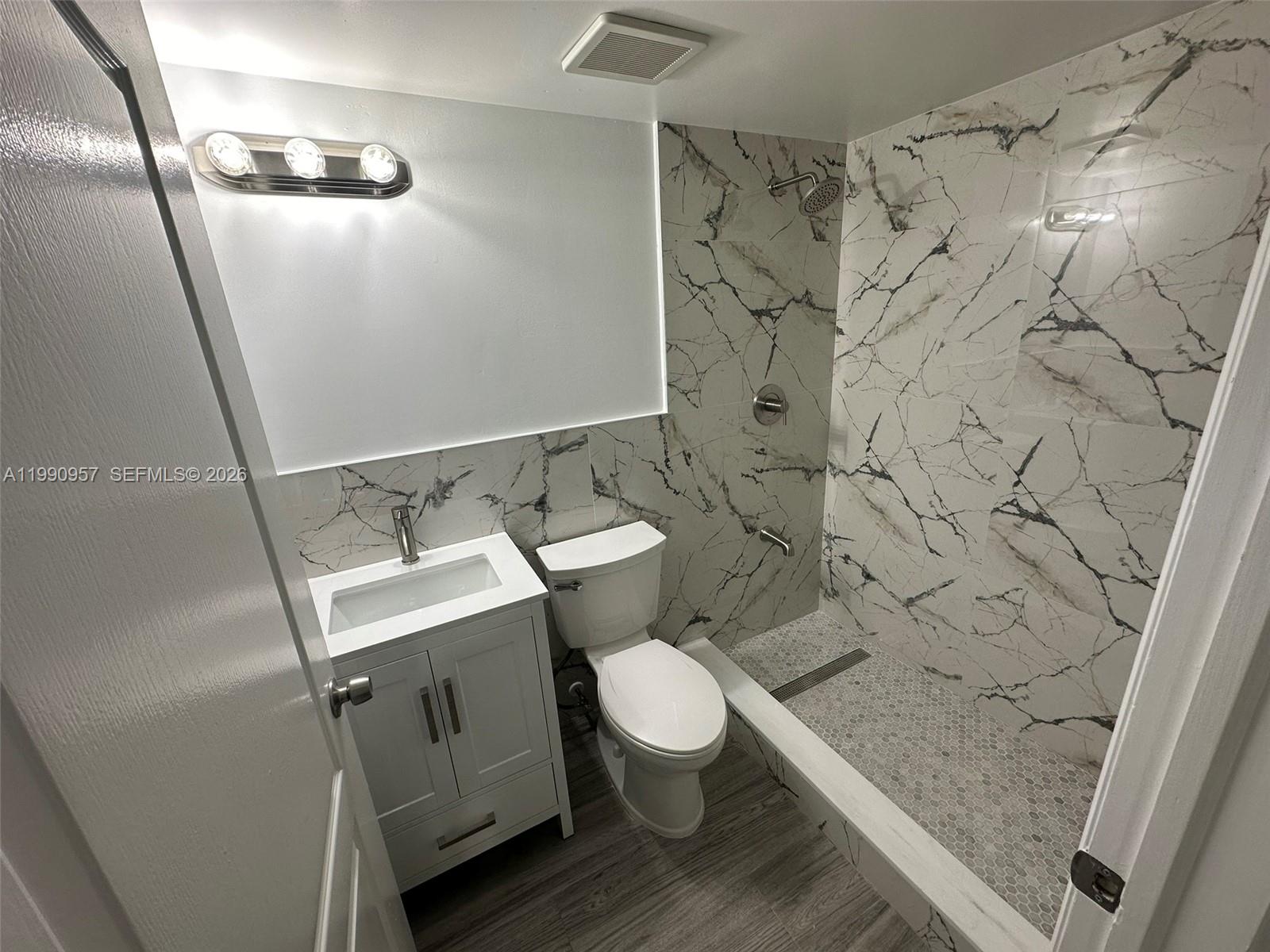 12005 Southwest 14th Street, Unit 403D Miami, FL 33184 - Photo 19 of 26 a bathroom with a sink and mirror with toilet