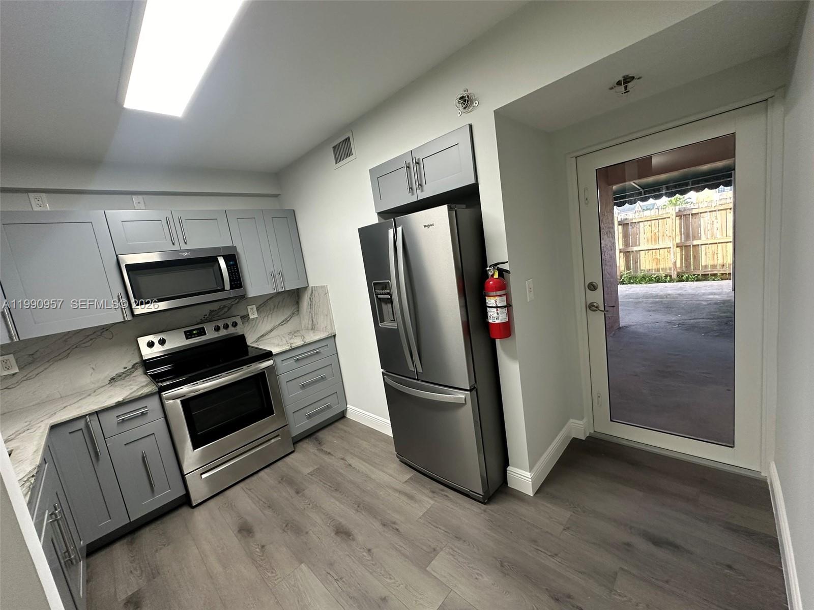 12005 Southwest 14th Street, Unit 403D Miami, FL 33184 - Photo 5 of 26 a kitchen with stainless steel appliances granite countertop a refrigerator and a stove