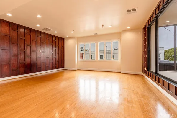 a view of an empty room with glass door and entryway