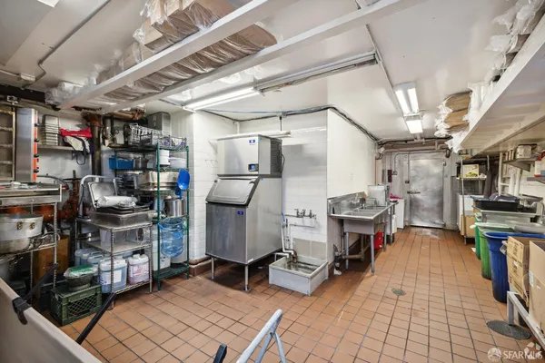 a storage room with washer and a view of kitchen