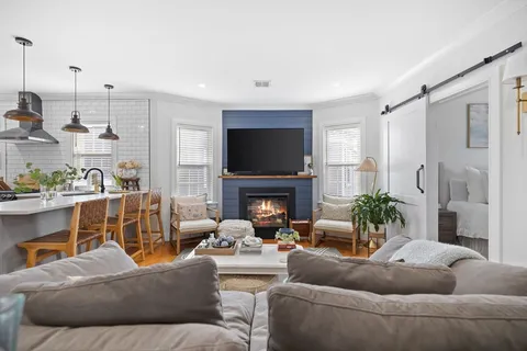 a living room with furniture a fireplace and a flat screen tv
