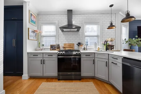 a kitchen with a stove sink and cabinets