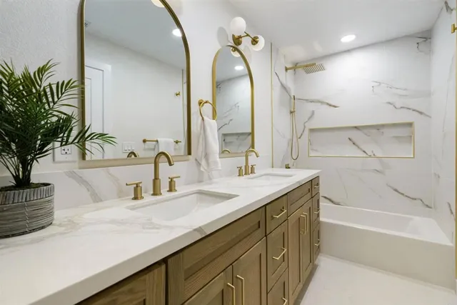 a bathroom with a granite countertop sink a large mirror and shower