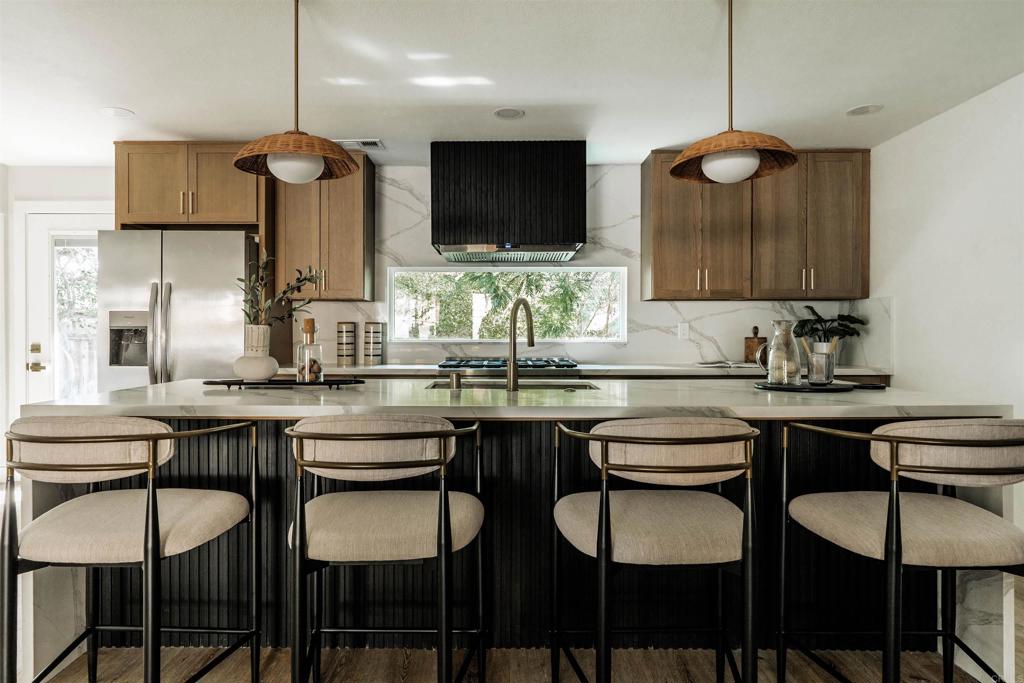 2275 Ivy Road Oceanside, CA 92054 - Photo 5 of 45 a kitchen with stainless steel appliances a dining table chairs and sink