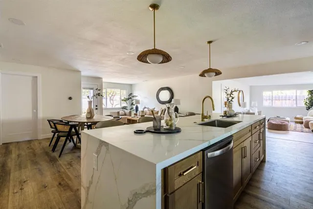 a kitchen with stainless steel appliances granite countertop a sink a stove and chairs