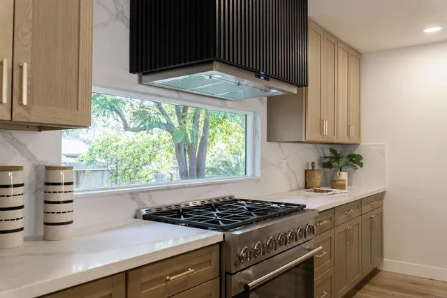 a kitchen with a stove a sink and a window