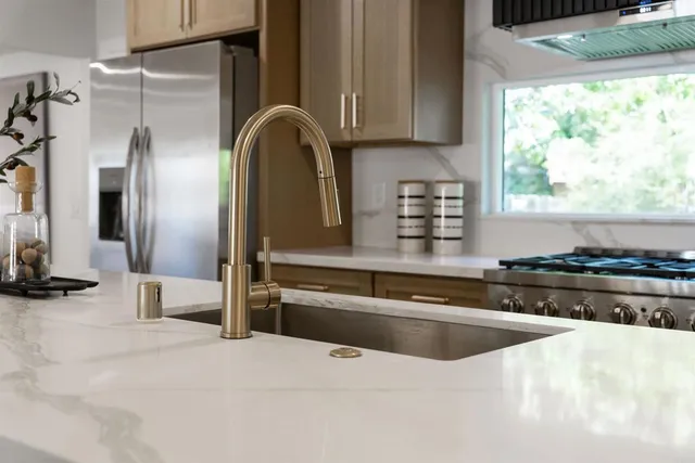 a kitchen with stainless steel appliances granite countertop a sink and a stove