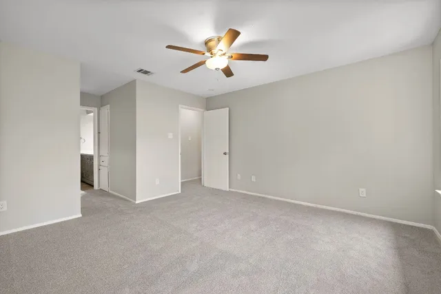 a view of an empty room with a ceiling fan