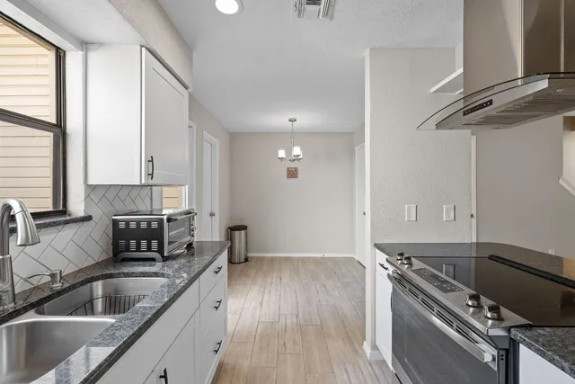 a kitchen with a sink stove and cabinets