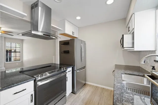 a kitchen with stainless steel appliances granite countertop a stove and a refrigerator