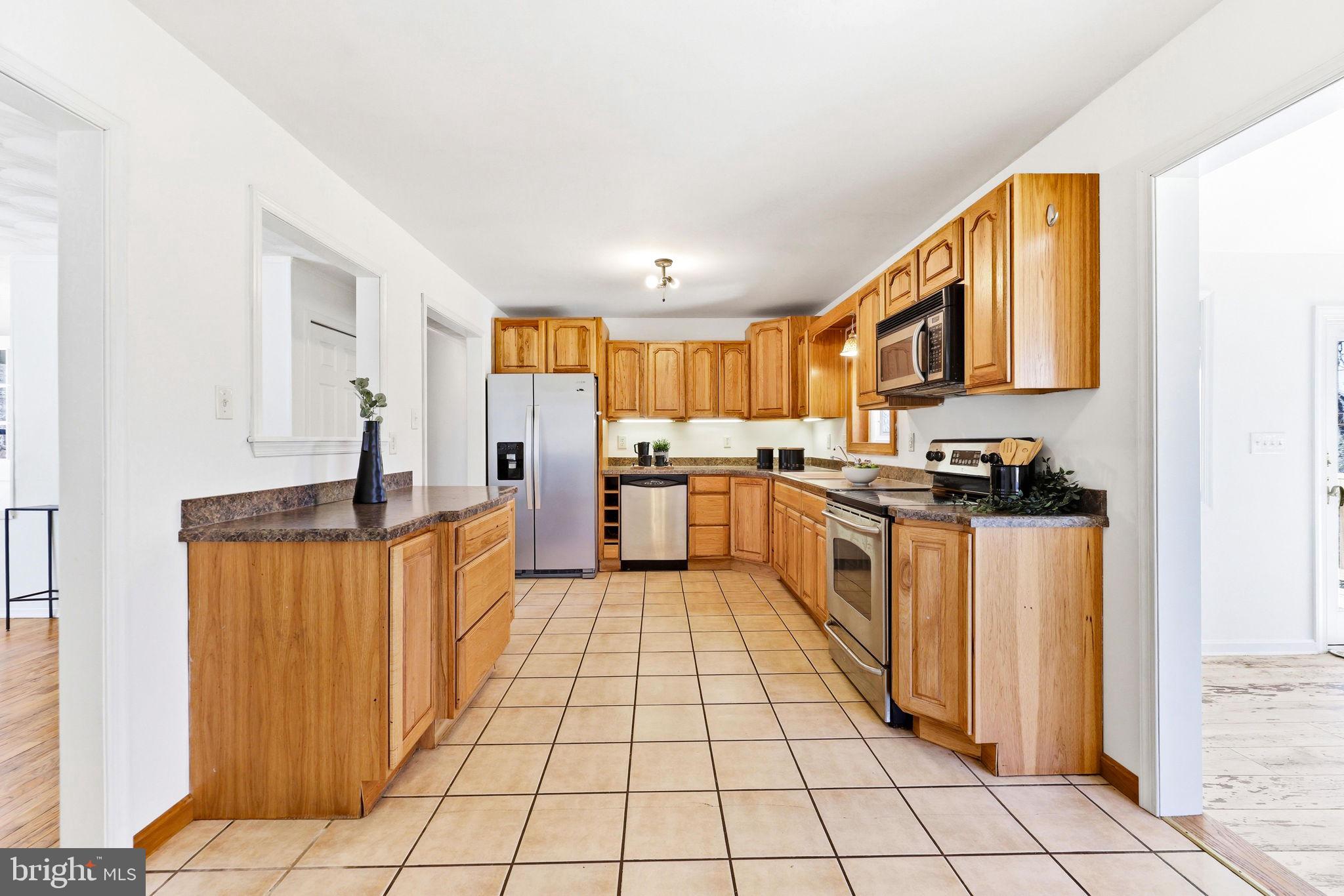 612 Ridge Road Finksburg, MD 21048 - Photo 18 of 39 a kitchen with stainless steel appliances granite countertop a stove a sink and a refrigerator