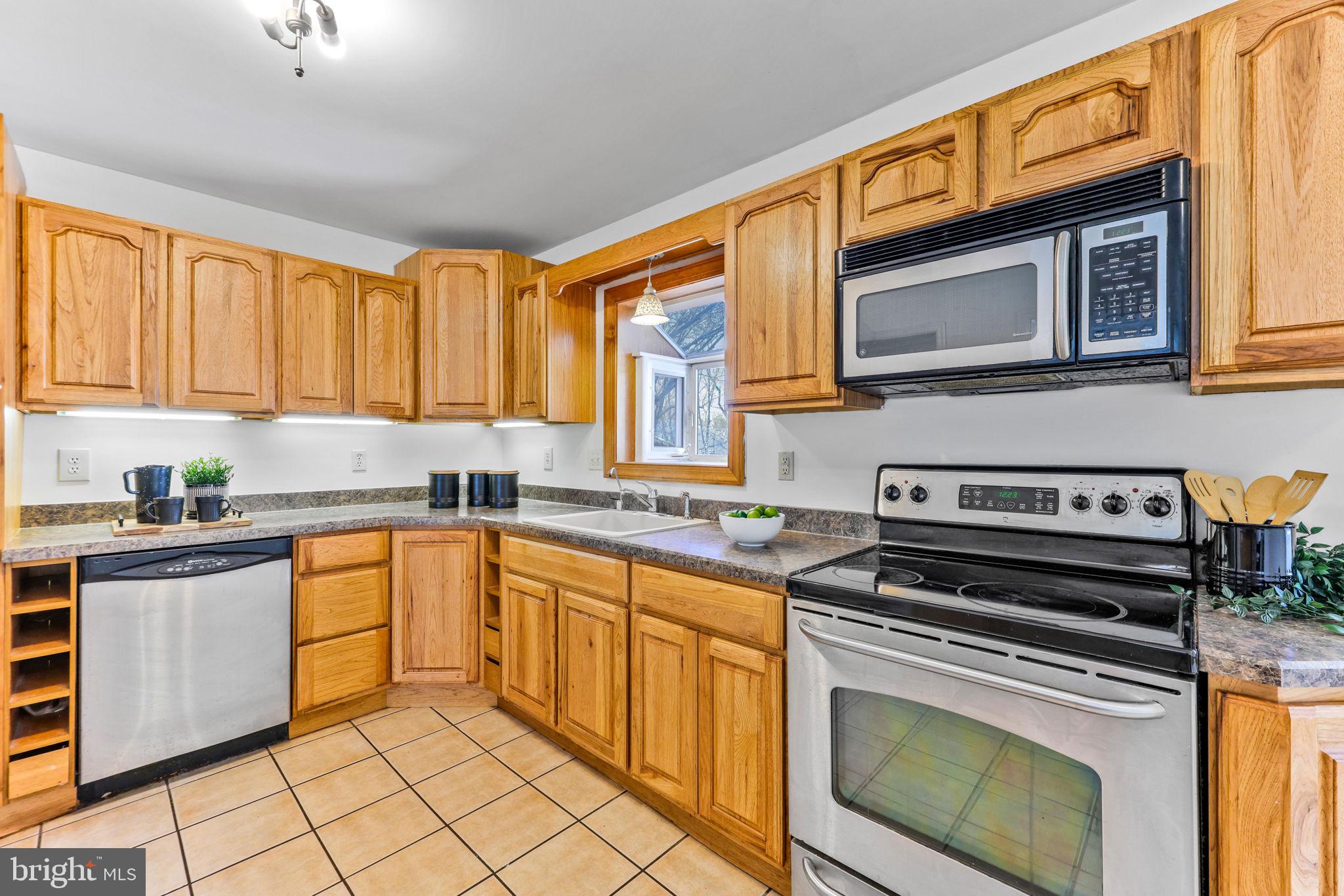 612 Ridge Road Finksburg, MD 21048 - Photo 7 of 39 a kitchen with stainless steel appliances granite countertop a stove a sink and a microwave