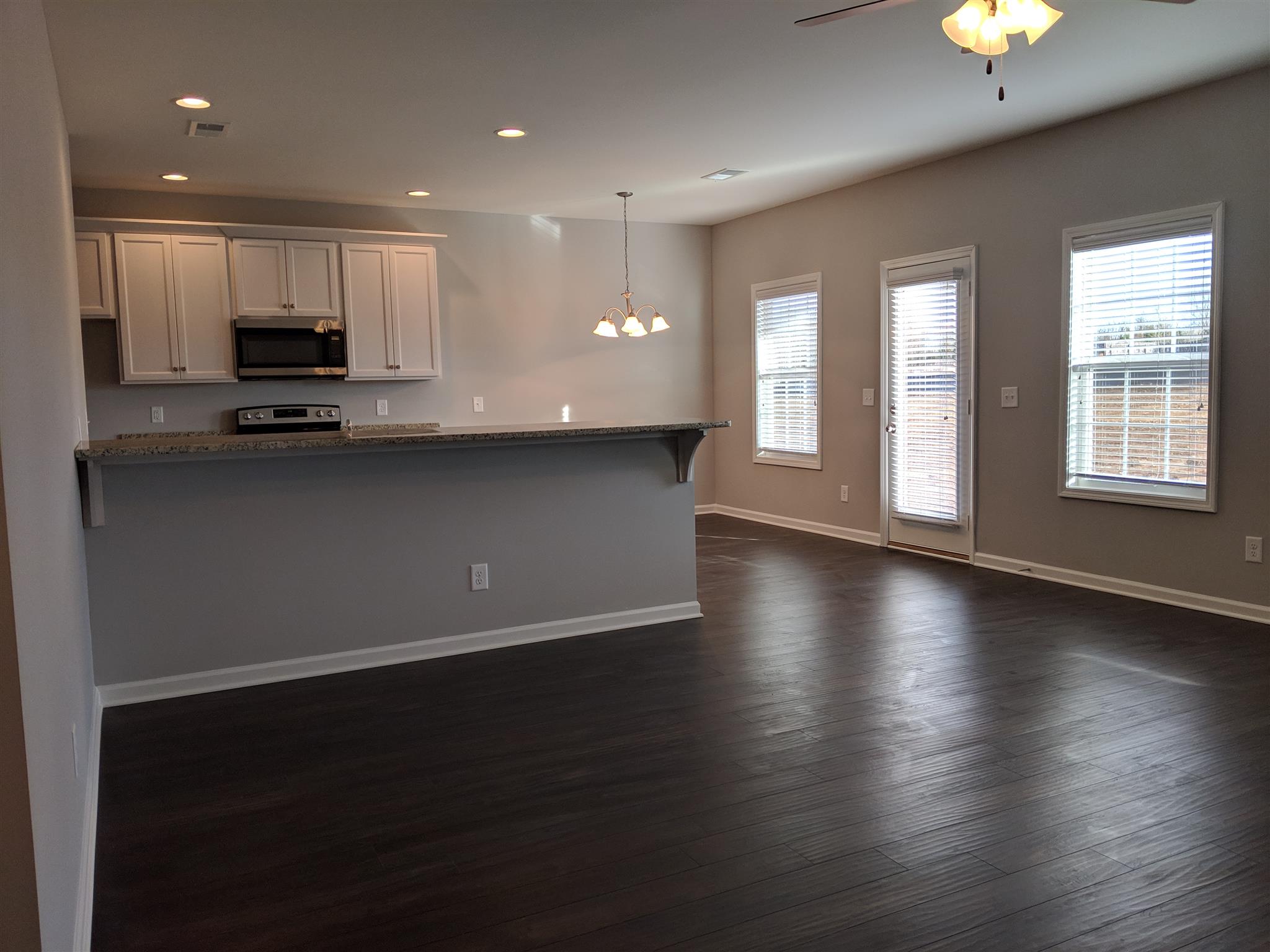 709 Mitscher Drive Spring Hill, TN 37174 - Photo 27 of 27 an open kitchen with kitchen island a sink wooden floor and a stove