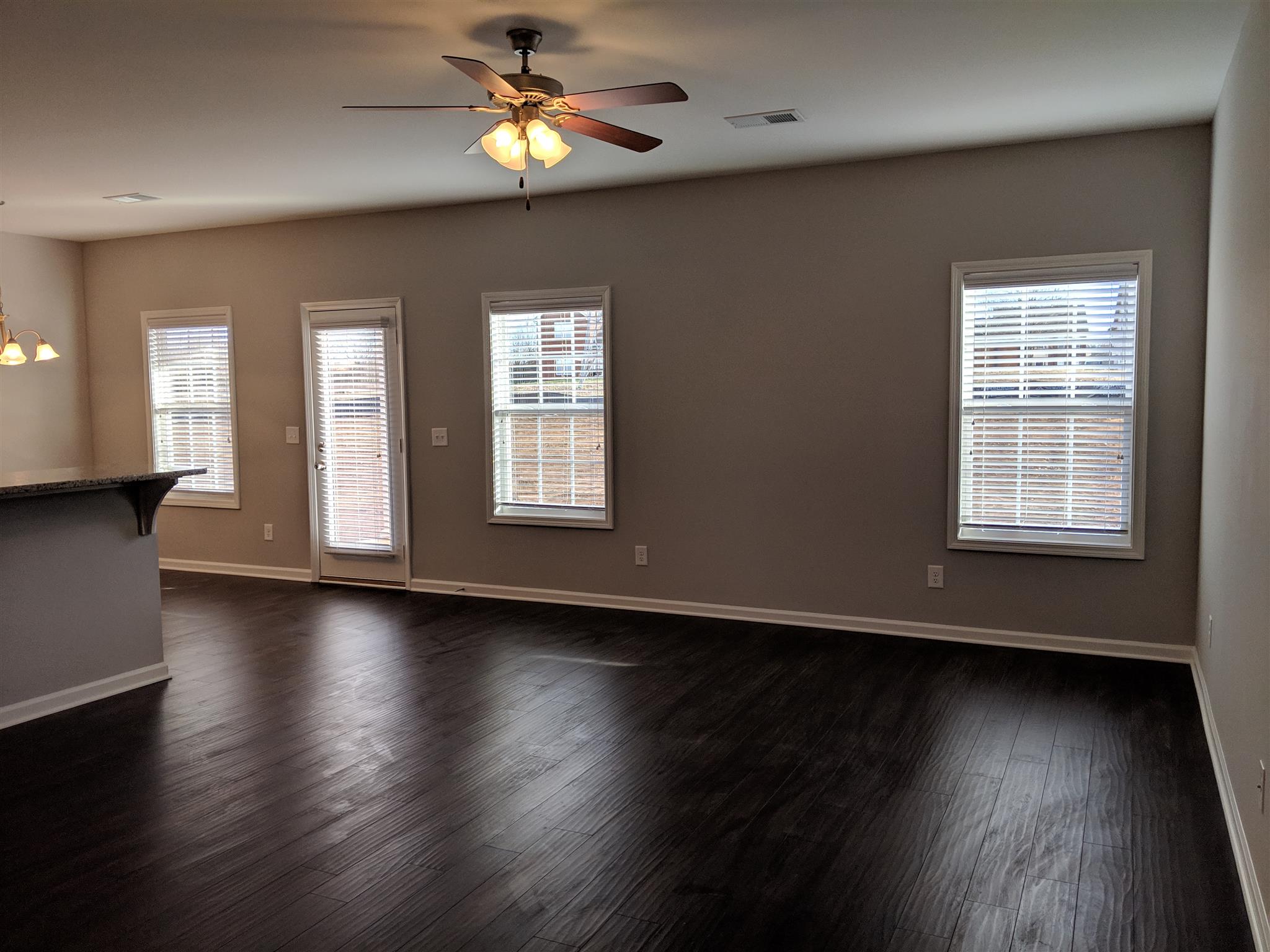 709 Mitscher Drive Spring Hill, TN 37174 - Photo 6 of 27 a view of an empty room with wooden floor and a window