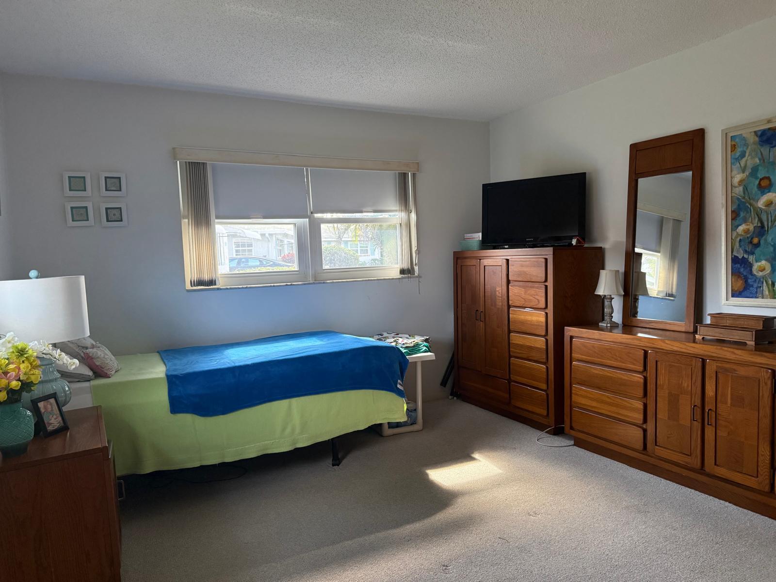 446 Bluebird Lane Delray Beach, FL 33445 - Photo 14 of 16 a bedroom with furniture and a flat screen tv