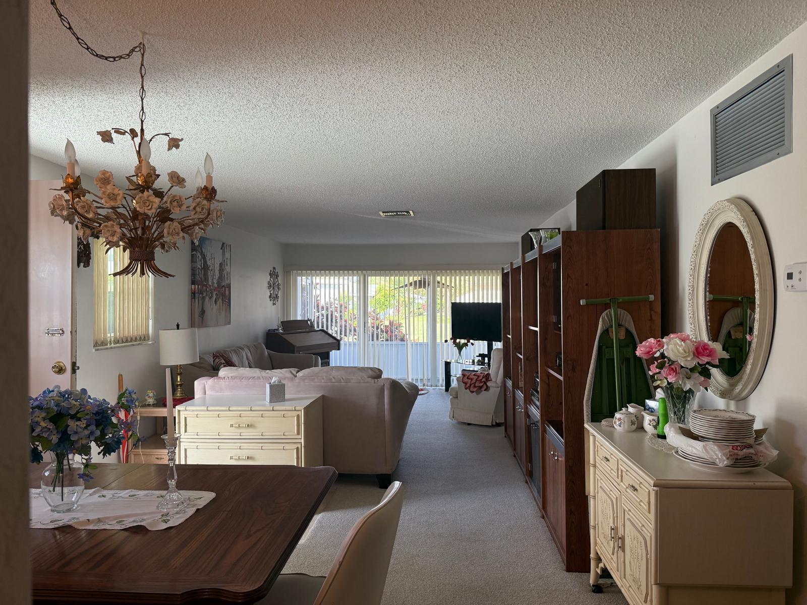 446 Bluebird Lane Delray Beach, FL 33445 - Photo 4 of 16 a living room with fireplace furniture and a chandelier