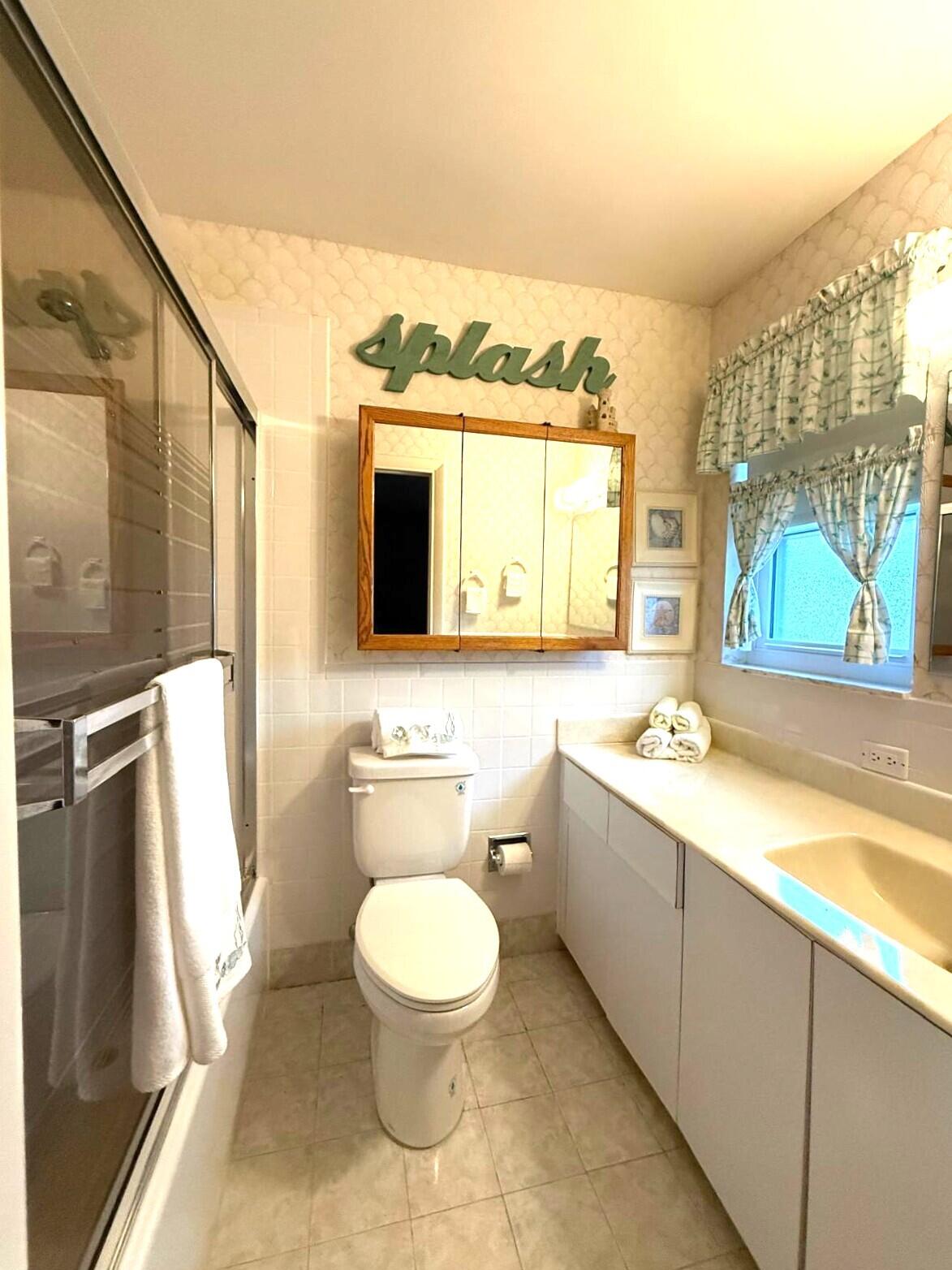 446 Bluebird Lane Delray Beach, FL 33445 - Photo 9 of 16 a bathroom with a granite countertop toilet sink and mirror