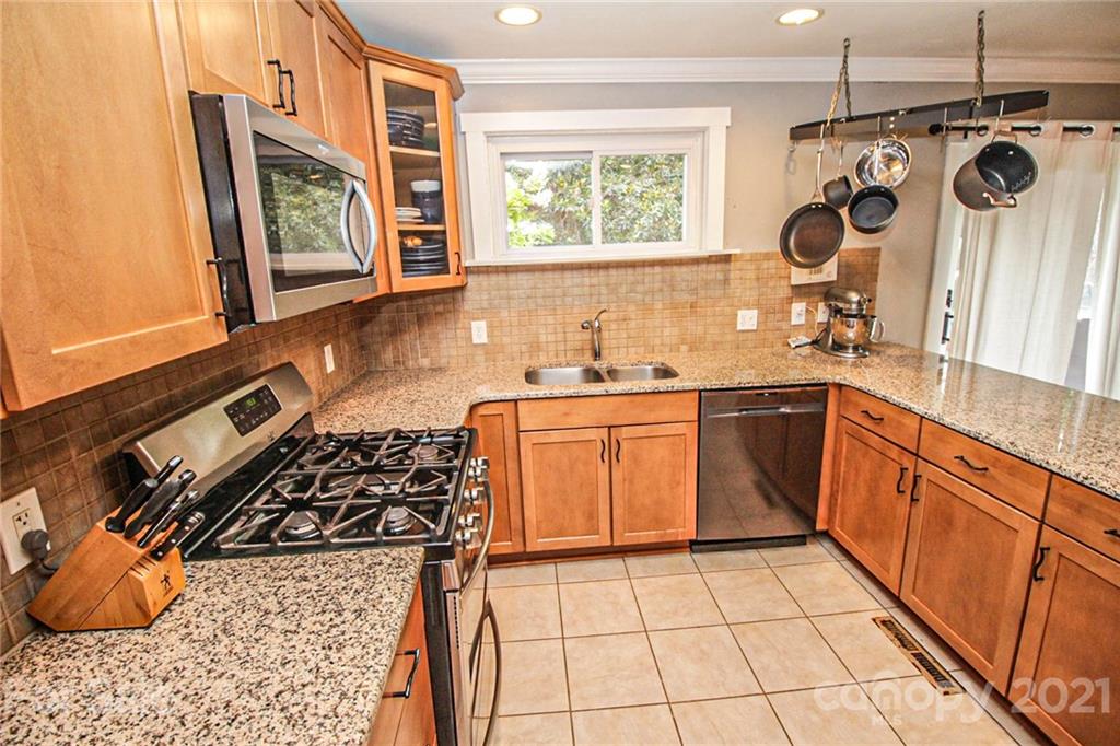 4227 Murrayhill Road Charlotte, NC 28209 - Photo 11 of 24 a kitchen with stainless steel appliances granite countertop a stove a sink and a microwave