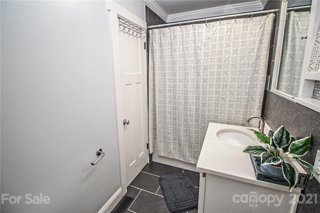 4227 Murrayhill Road Charlotte, NC 28209 - Photo 19 of 24 a bathroom with a shower curtain and a sink