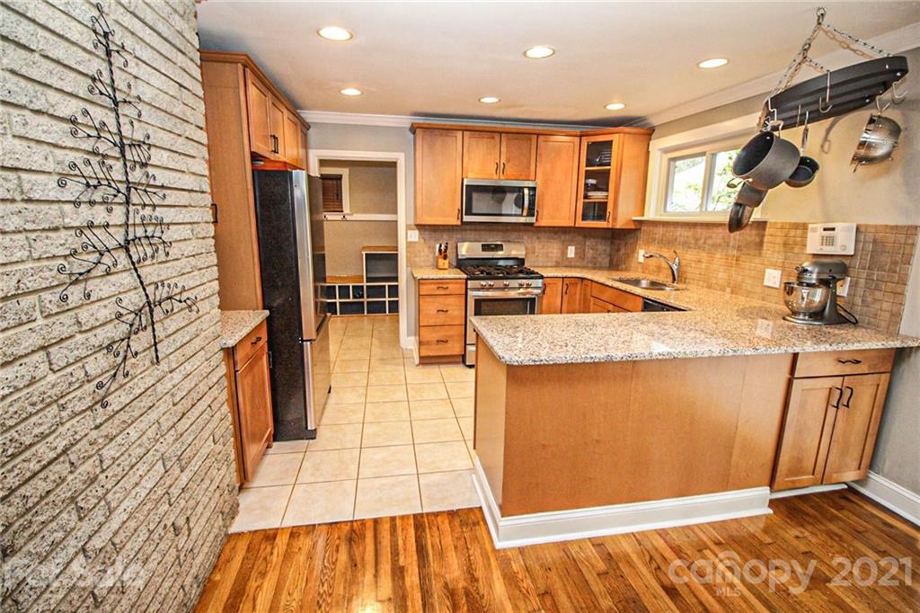 4227 Murrayhill Road Charlotte, NC 28209 - Photo 10 of 24 a kitchen with stainless steel appliances granite countertop a refrigerator a sink a stove and white cabinets