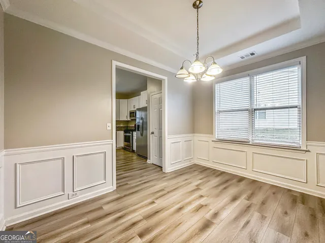a view of a livingroom with a chandelier fan and windows