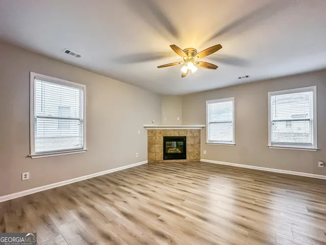a view of an empty room with a window and a fireplace