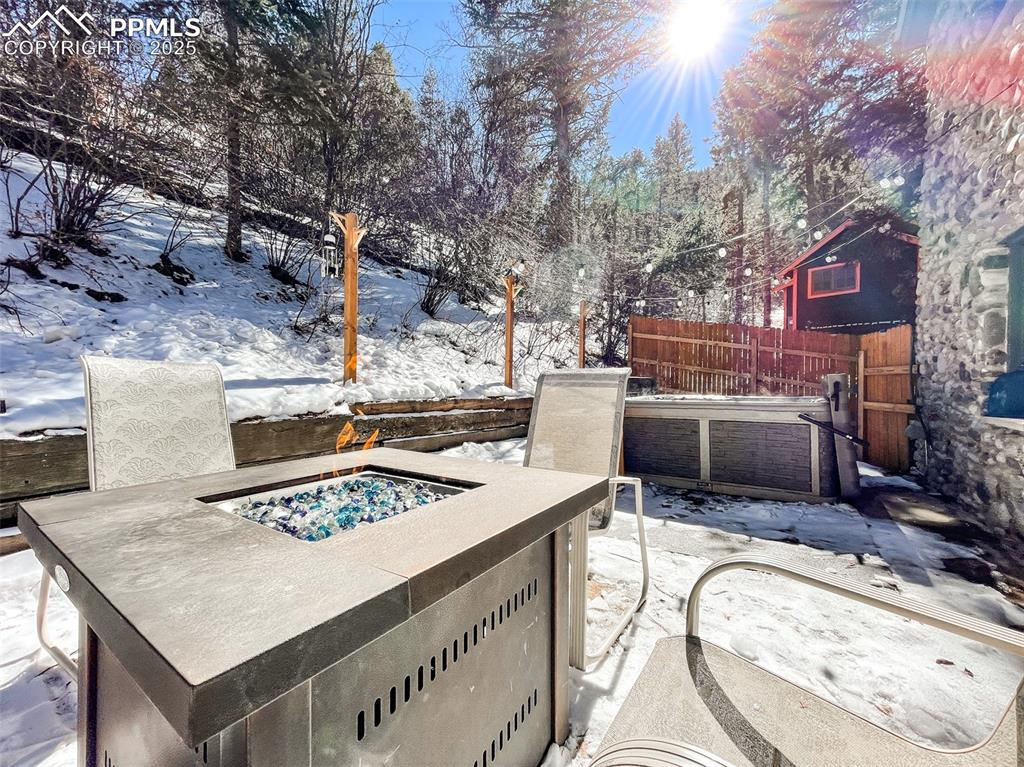 6025 Sioux Trail Cascade, CO 80809 - Photo 14 of 42 a roof deck with table and chairs with barbeque and wooden fence