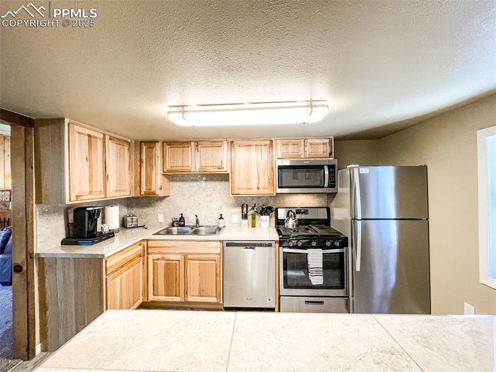 6025 Sioux Trail Cascade, CO 80809 - Photo 16 of 42 a kitchen with a sink a stove and refrigerator