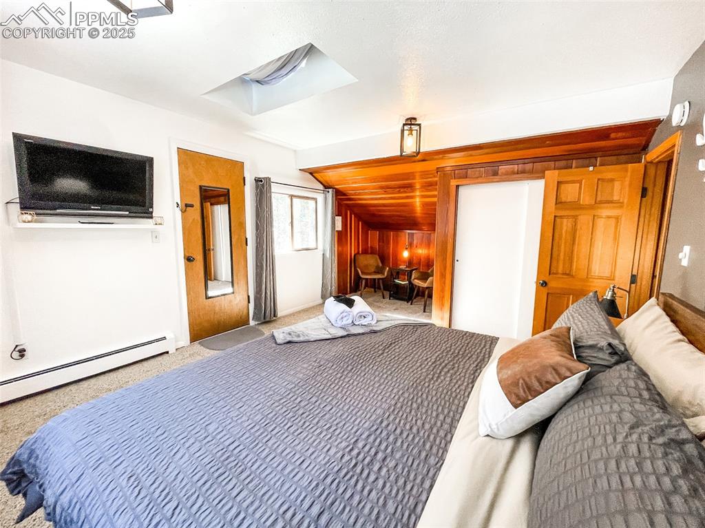 6025 Sioux Trail Cascade, CO 80809 - Photo 32 of 42 a bedroom with a bed and a flat screen tv