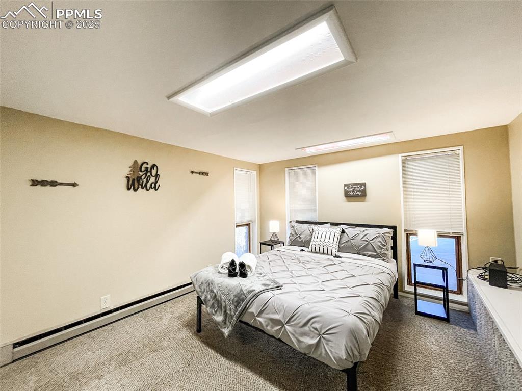 6025 Sioux Trail Cascade, CO 80809 - Photo 35 of 42 a bedroom with a bed and a dresser with rug