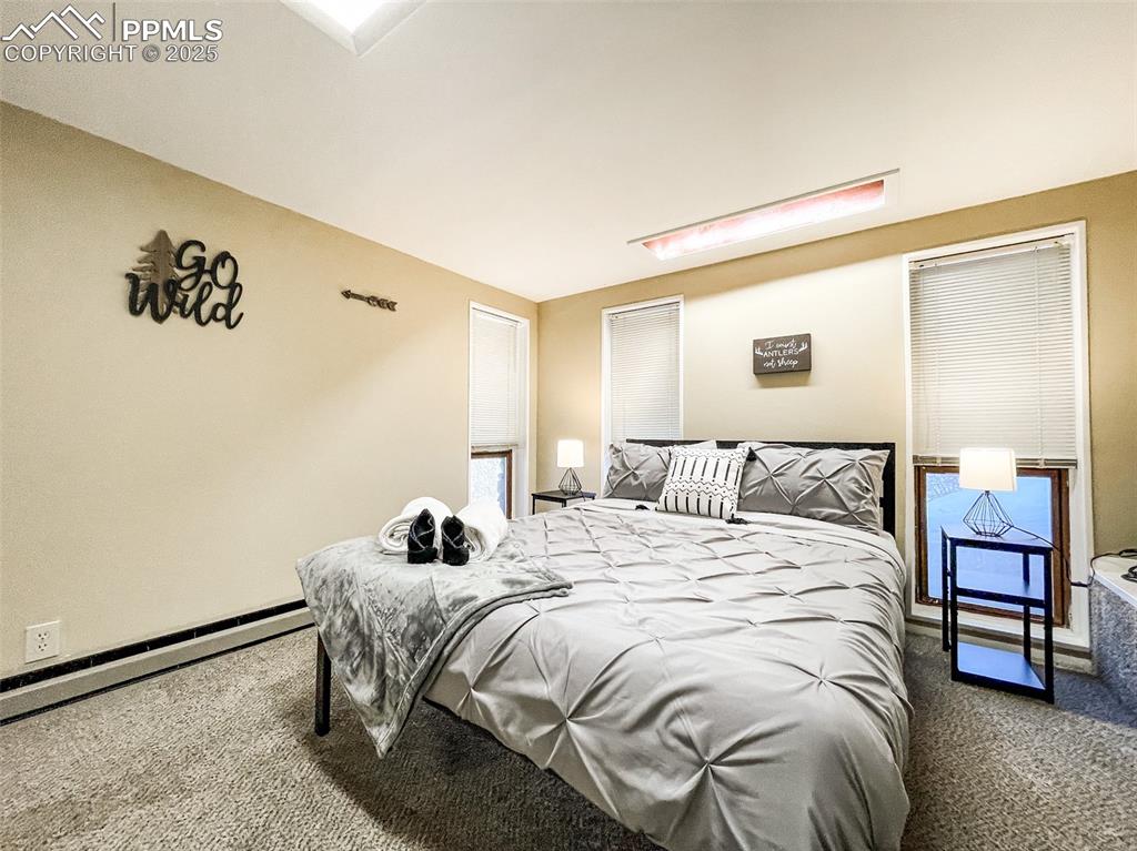 6025 Sioux Trail Cascade, CO 80809 - Photo 36 of 42 a bedroom with a bed and a lamp with window