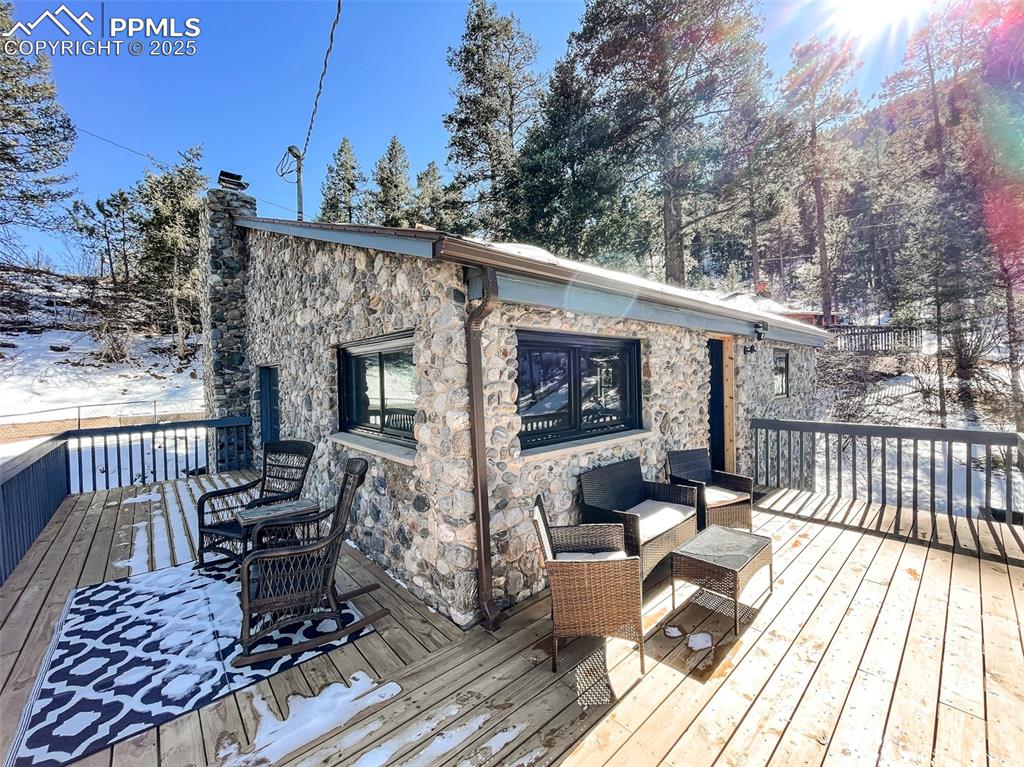 6025 Sioux Trail Cascade, CO 80809 - Photo 4 of 42 a view of a patio with couches table and chairs with wooden floor