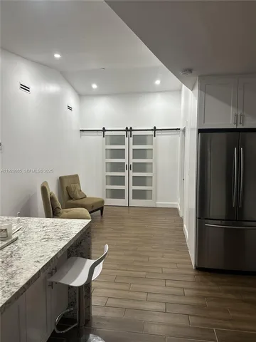 a view of kitchen with refrigerator microwave and wooden floor