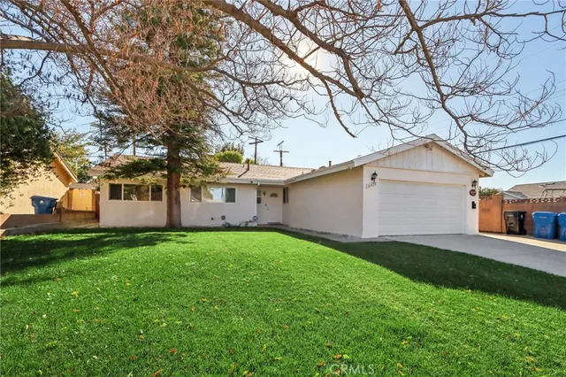 a view of a yard in front of a house with large trees